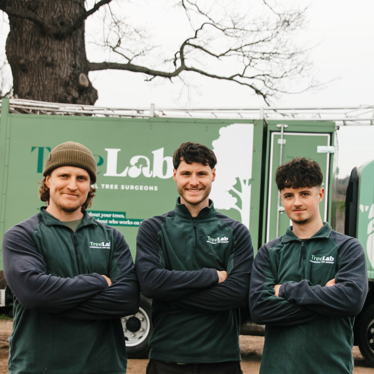 3 arborists who work for treelab standing in front of branded van.